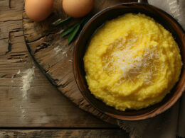 Una citola piena di polenta a base di farina di mais servita su un tagliere in legno