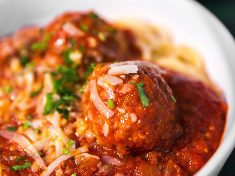 un piatto di spaghetti conditi con delle polpette al sugo, simboleggia uno dei pilastri della cucina italiana e della cucina romana