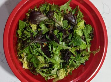 una ciotola rossa piena di foglie di insalata