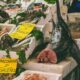un frame di un mercato del pesce con in vendita un pezzo di pesce spada di cui si intravede l'interno e il prezzo