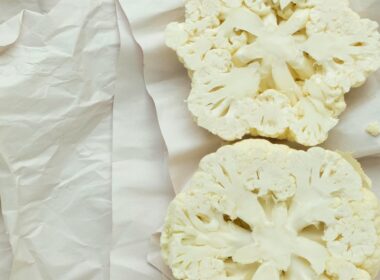un cavolfiore bianco crudo tagliato a mo di bistecca posato su un panno bianco e pronto da mangiare crudo