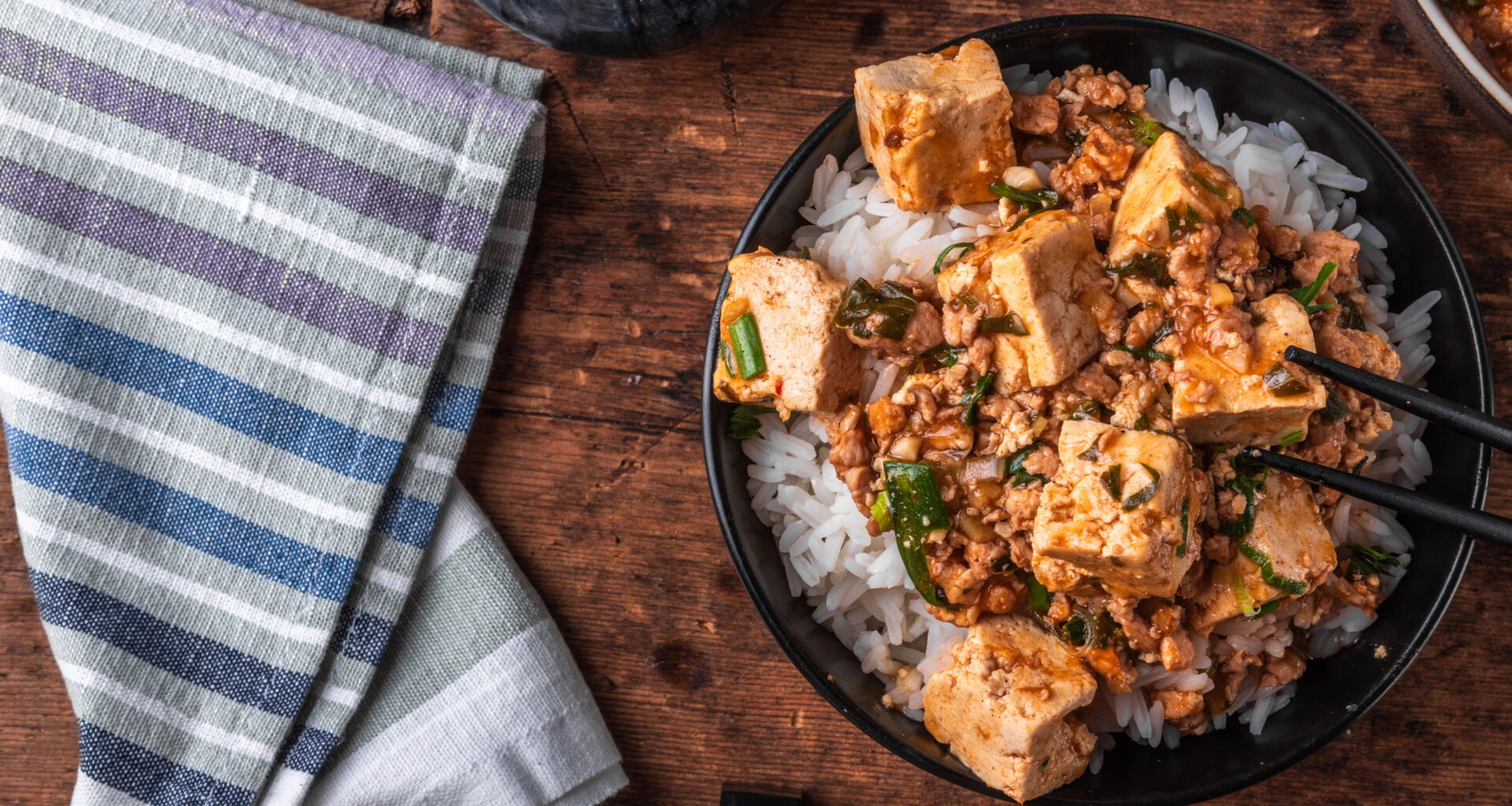 una bowl di riso e tofu marinato e affumicato condita con del coriandolo