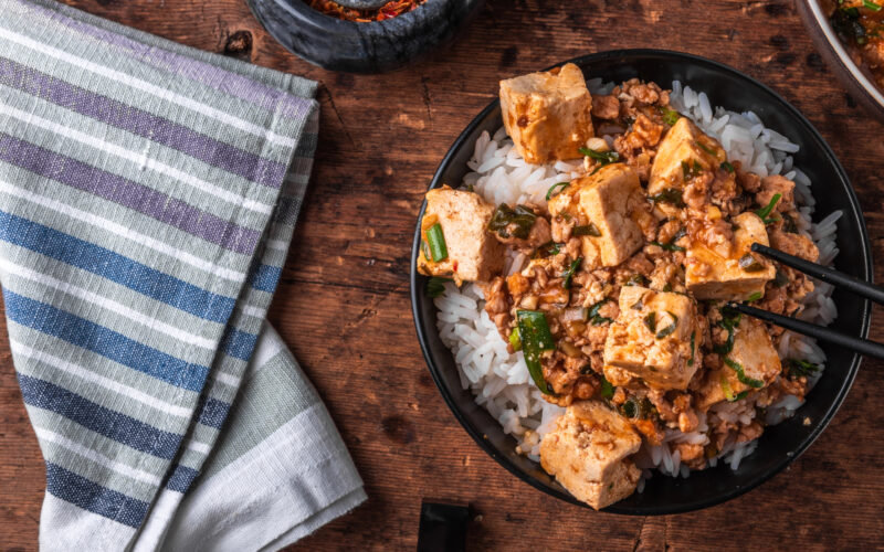 una bowl di riso e tofu marinato e affumicato condita con del coriandolo
