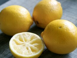 3 limoni interi e una metà giacciono su un tavolo grigio
