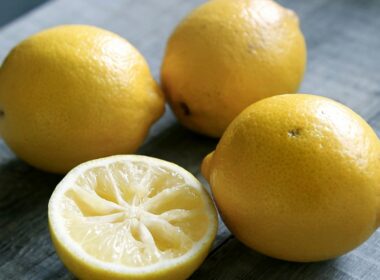 3 limoni interi e una metà giacciono su un tavolo grigio