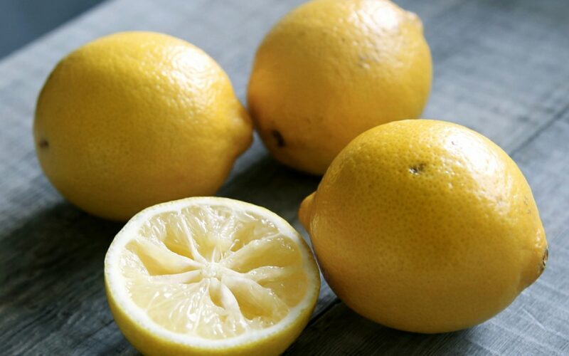 3 limoni interi e una metà giacciono su un tavolo grigio