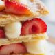 una millefoglie farcita con crema pasticcera, fragole e zucchero a velo