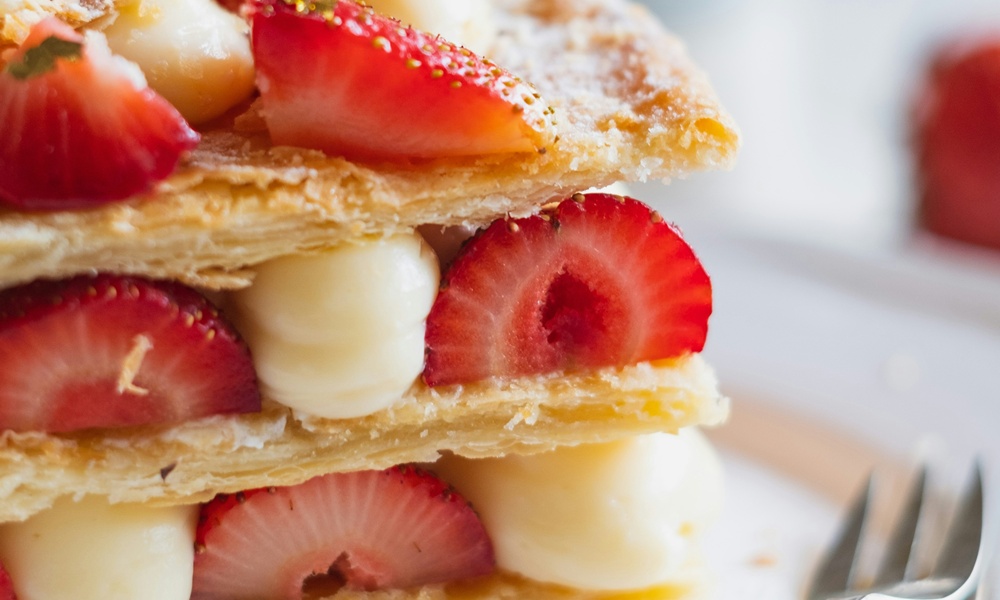 una millefoglie farcita con crema pasticcera, fragole e zucchero a velo