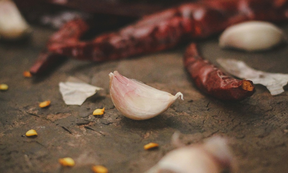 spicchio di aglio pelato intero vicino a dei peperoncini