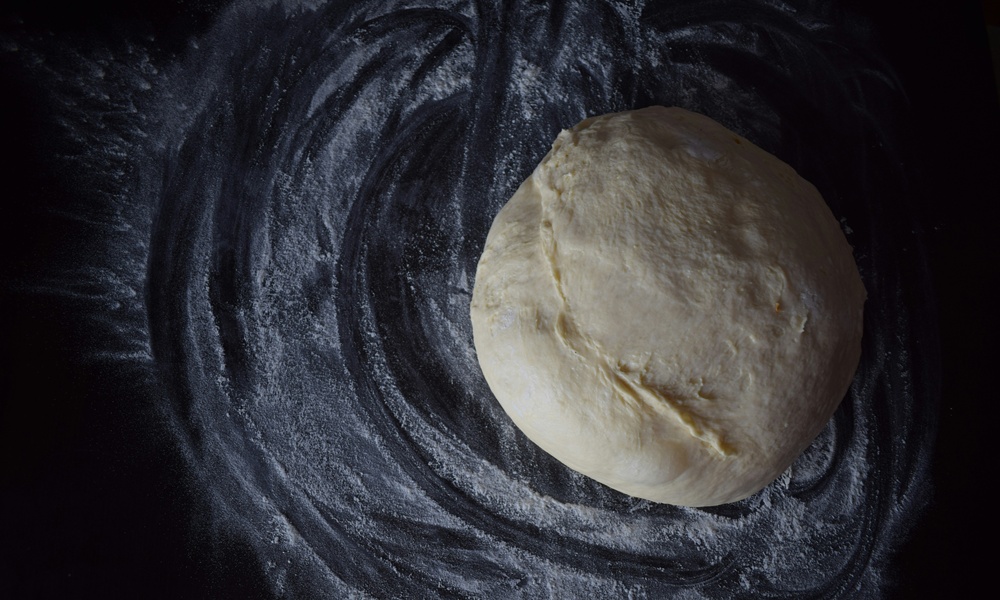 un panetto di massa pronto per essere steso e farcito per preparare una pizza