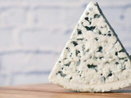 una fetta di gorgonzola su un tagliere in legno