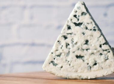 una fetta di gorgonzola su un tagliere in legno