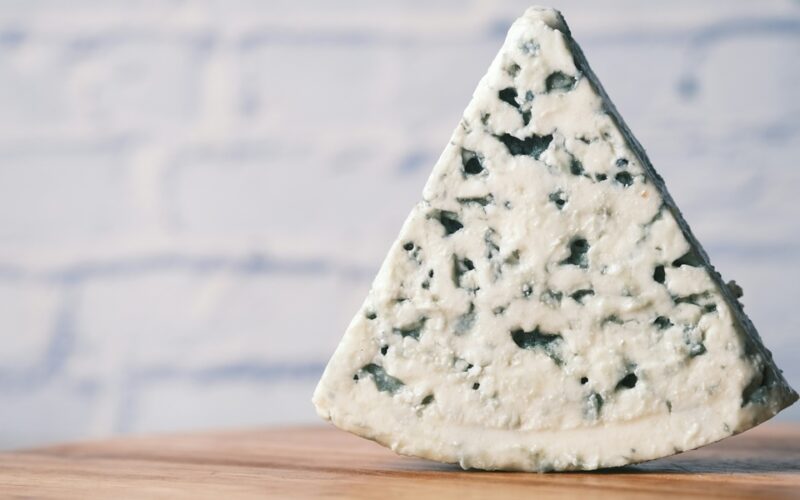 una fetta di gorgonzola su un tagliere in legno