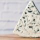 una fetta di gorgonzola su un tagliere in legno