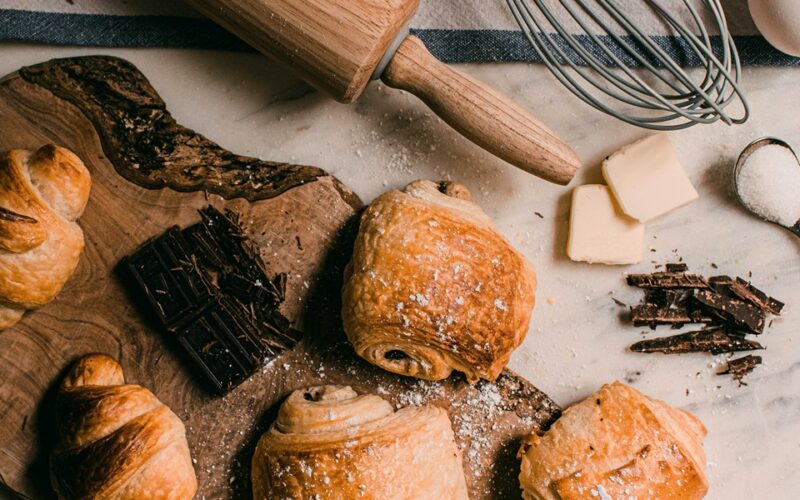 due pain au chocolate poggiati su un tagliere in legno