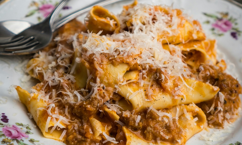 un piatto con della pappa al pomodoro condita con del formaggio grattuggiato