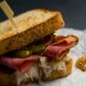 Un toast farcito con un salume cotto, olive, craturi e tostato