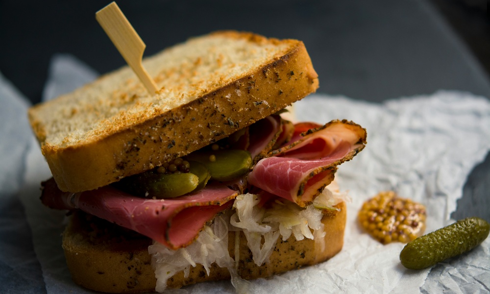 Un toast farcito con un salume cotto, olive, craturi e tostato