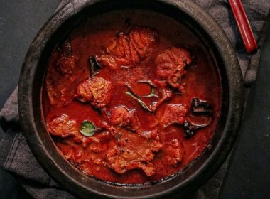 una pentola nera in ghisa che contiene uno spezzatino o un gulasch a base di carne