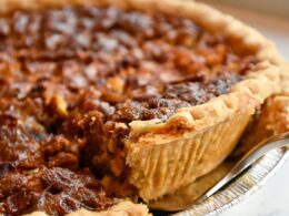 Un close up di una torta da credenza con una base di frolla ripiena di marmellata e frutta secca