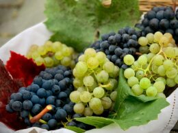 un cesto pieno di grappoli di uva da tavola di colore bianco e rosso/nero