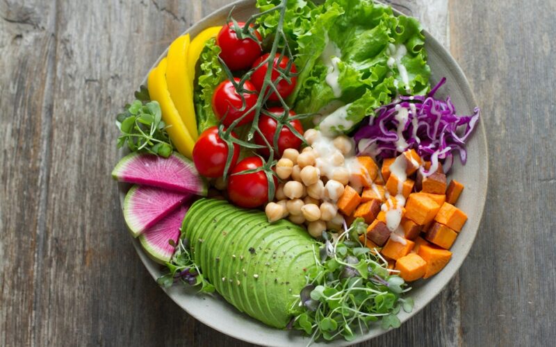 un piatto sano con tutti gli alimenti e i componenti necesari: verudre, pomodri, avocado, legumi, zucca