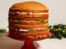 un panettone gastronomico farcito e posizionato su un'alzatina su una tavola imbandita