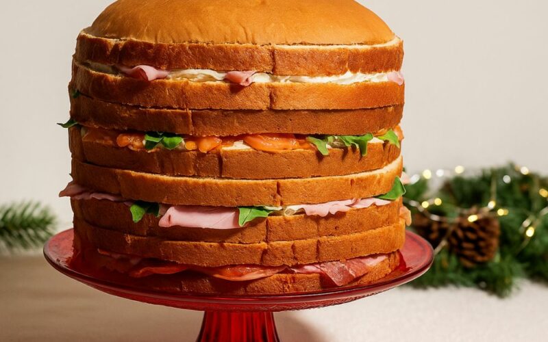 un panettone gastronomico farcito e posizionato su un'alzatina su una tavola imbandita