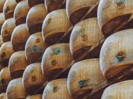 una fila di forme di parmigiano reggiano impilate nelle stanze in cui si fa la stagionatura