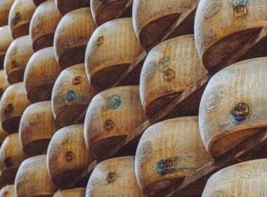 una fila di forme di parmigiano reggiano impilate nelle stanze in cui si fa la stagionatura