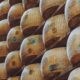 una fila di forme di parmigiano reggiano impilate nelle stanze in cui si fa la stagionatura