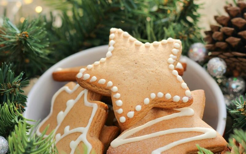 dei biscottini di natale a forma di omino e stelle, decorati e pronti per essere appesi all'albero di natale