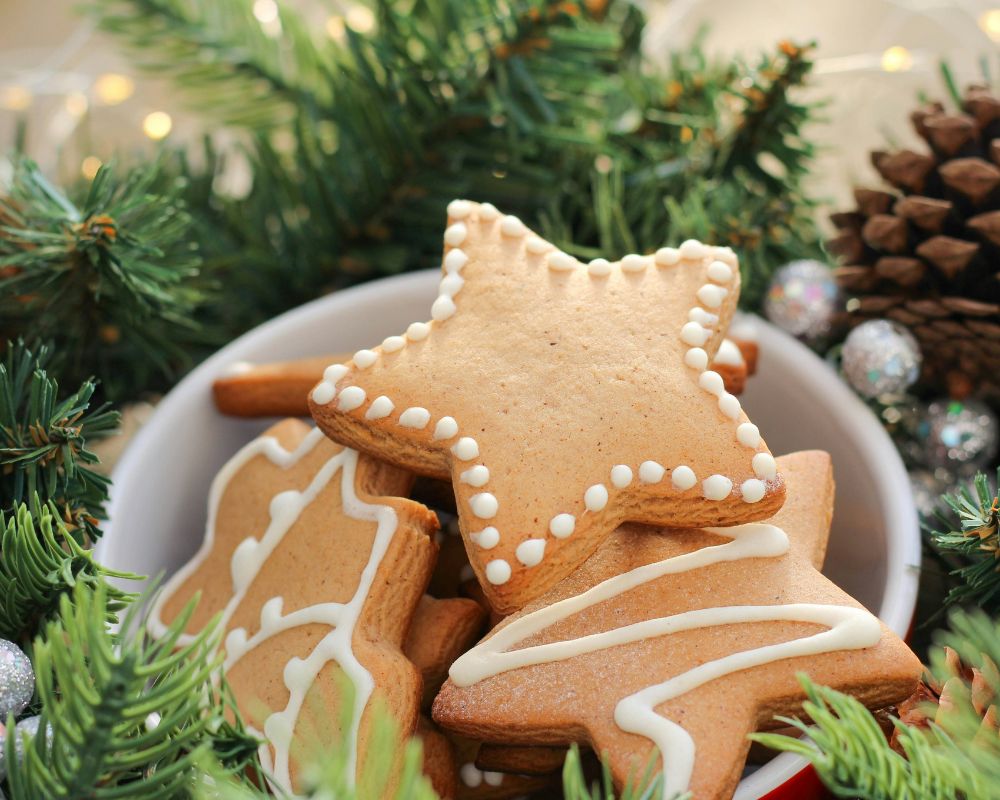 dei biscottini di natale a forma di omino e stelle, decorati e pronti per essere appesi all'albero di natale