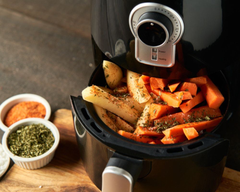 una friggitrice ad aria che ha delle verdure in cottura