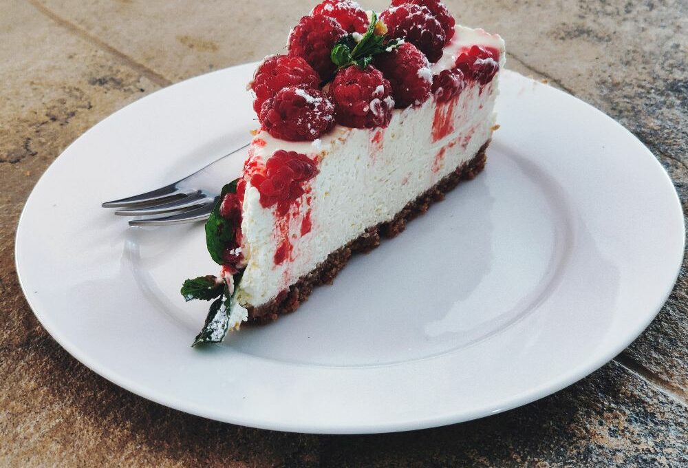 una fetta di cheesecake servita su un piatto da dolci bianco