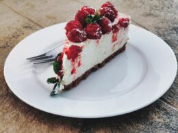 una fetta di cheesecake servita su un piatto da dolci bianco