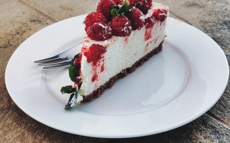 una fetta di cheesecake servita su un piatto da dolci bianco