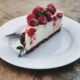 una fetta di cheesecake servita su un piatto da dolci bianco